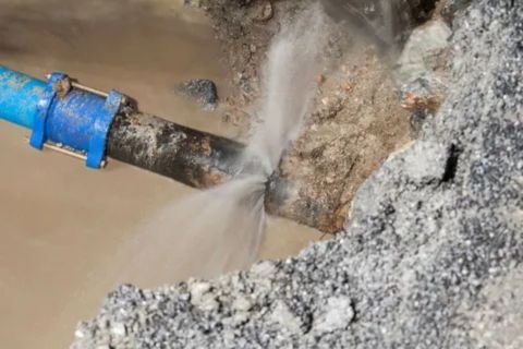 A close-up of a damaged water pipe, which is actively spraying a jet of water from a visible crack into a muddy trench.
Fixitnow provides the best pipe burst plumber in downtown dubai.