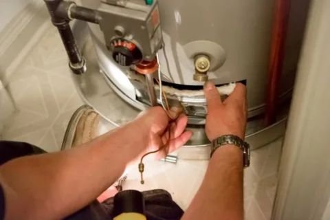 Close-up of a technician's hands working on the gas control valve and pilot light assembly of a residential water heater.
24-hour water heater repair in dubai marina by fixitnow
