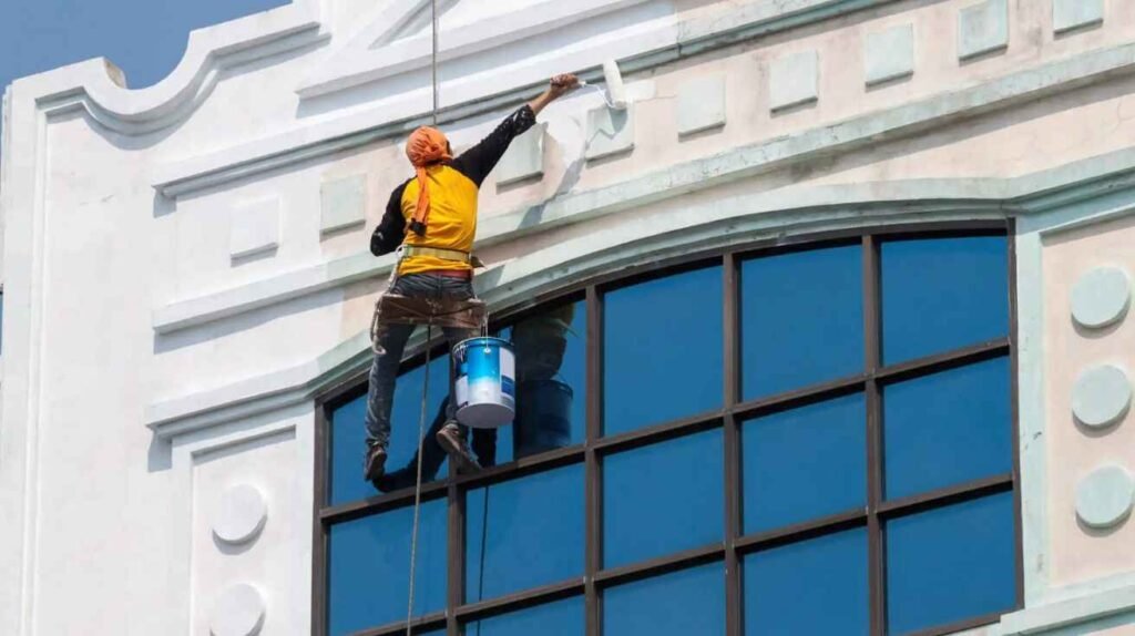 Painters applying UV-resistant paint on a villa exterior in Dubai’s heat.
