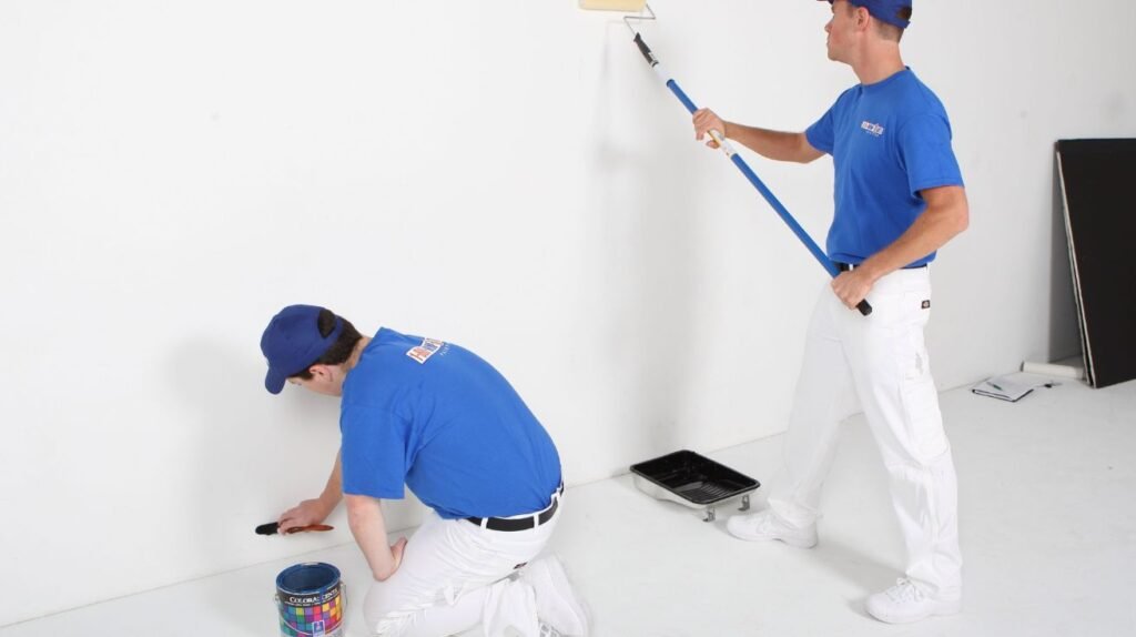 Painter working on bright interior walls of a Dubai villa using low-VOC paint.